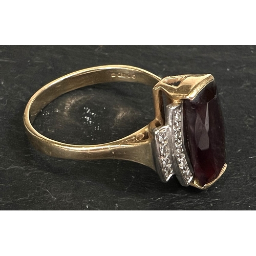 753 - An Art Deco style dress ring set garnet surrounded by 18 small diamonds, 18 carat yellow gold shank,... 