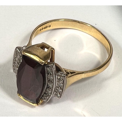 753 - An Art Deco style dress ring set garnet surrounded by 18 small diamonds, 18 carat yellow gold shank,... 