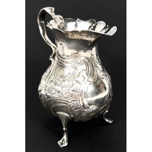 775 - A mid Georgian silver cream jug of baluster form with repousse decoration, London  1755, maker S.M.,... 