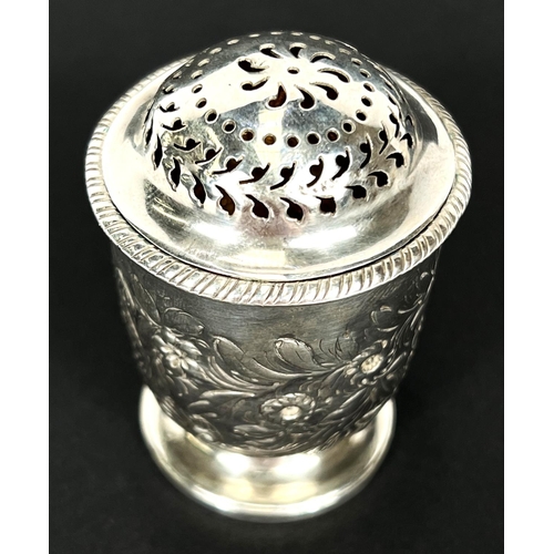 778 - A late Georgian silver muffineer, cylindrical form with repousse decoration and domed top, on pedest... 