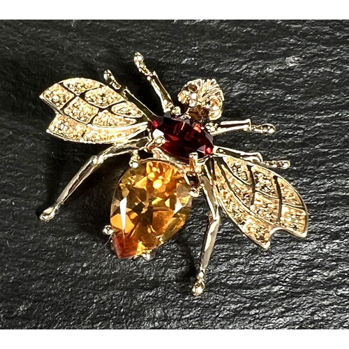 790 - A 10k gold brooch in the form of a bee, set with garnets and citrine coloured stones