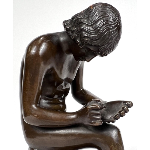 832 - A bronze nude man, seated and pulling a thorn from his foot, on marble base, unsigned, height 18cm