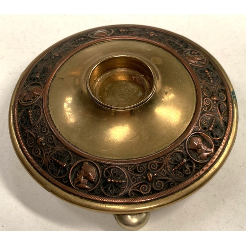 91 - A Victorian brass circular inkwell decorated with relief copper band depicting male head silhouettes... 