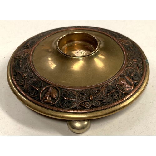 91 - A Victorian brass circular inkwell decorated with relief copper band depicting male head silhouettes... 