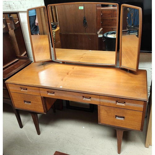 921 - A 1960's teak 2 piece bedroom suite by Butilux, comprising kneehole dressing table and 4 height ches... 