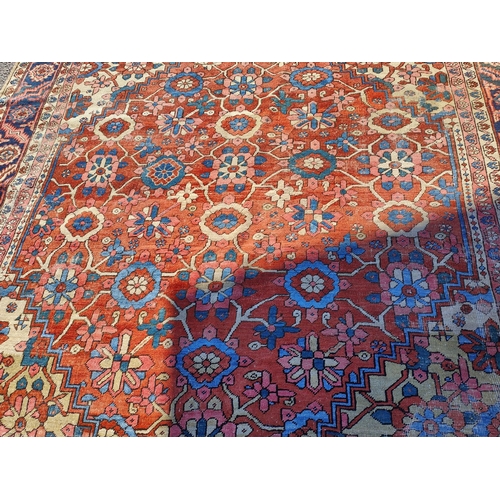 939A - A 19th century cream and red ground hand knotted Persian carpet with multiple borders and large cent... 