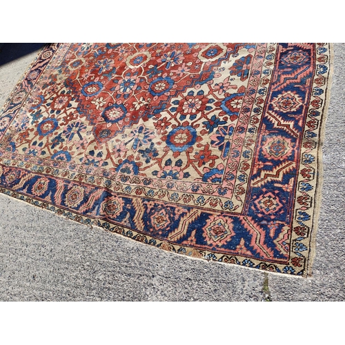 939A - A 19th century cream and red ground hand knotted Persian carpet with multiple borders and large cent... 