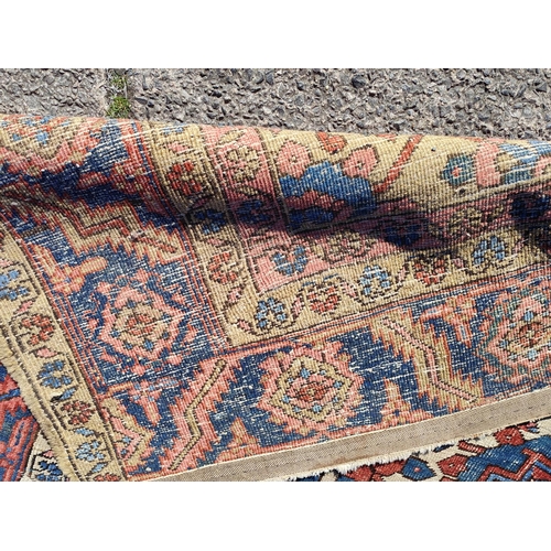 939A - A 19th century cream and red ground hand knotted Persian carpet with multiple borders and large cent... 