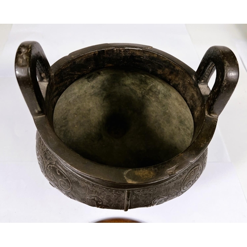 469 - A Chinese bronze censer with 2 large hoops and fitted pierced wooden lid with jade finial, on 3 legs... 