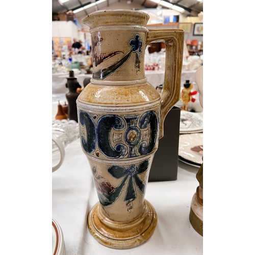 538 - A tall tapering stoneware jug by Martin Bros, the neck decorated with flying birds, the lower body w... 