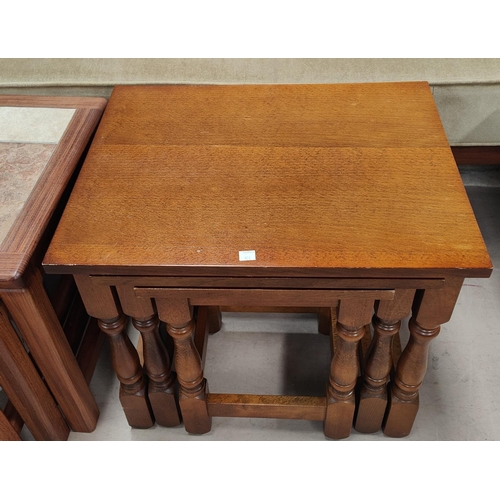 920 - An oak 2 tier coffee table; a nest of 3 oak occasional tables