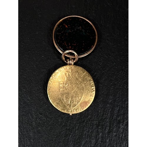 680A - A George III spade guinea (date worn) in gold and bloodstone locket (tests as 14ct), 14.0gm