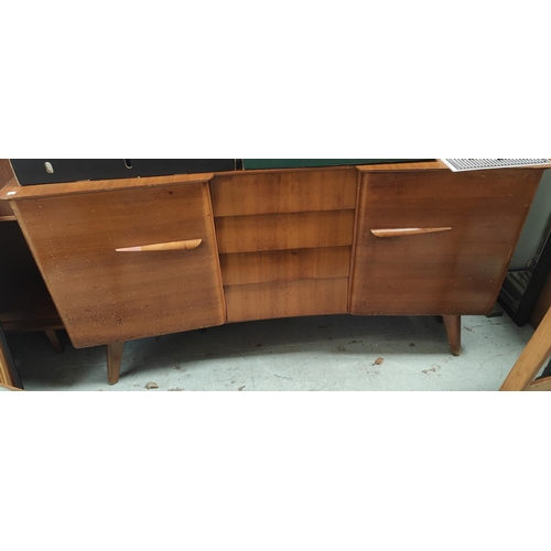 1003 - A mid 20th century light wood sideboard with angled and stepped front, four central drawers and two ... 