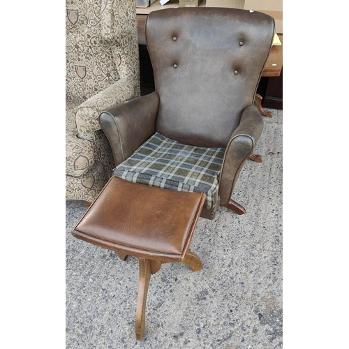 1034 - A brown leather effect button wing back armchair on rotating pedestal base with stool