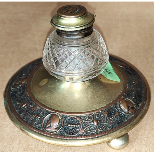 91 - A Victorian brass circular inkwell decorated with relief copper band depicting male head silhouettes... 