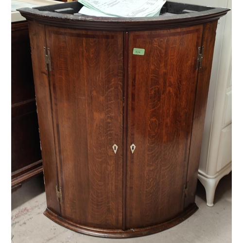 934 - An 18th century Georgian bow front corner cupboard in crossbanded mahogany with moulded cornice, enc... 