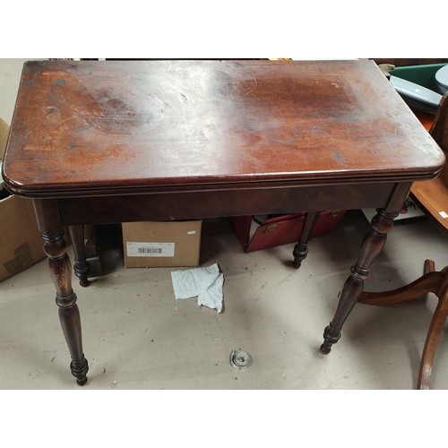 977 - A Georgian mahogany fold over tea table with rounded rectangular top, turned legs