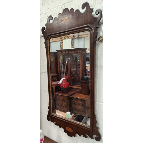 985A - A Sheraton style wall mirror in mahogany frame with inlay of shells to top and bottom