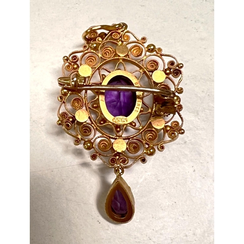 640 - A yellow metal filigree pendant brooch set seed pearls and 2 amethysts, stamped '15c', 5gm