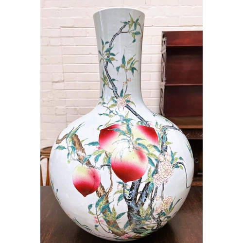 559 - A very large Chinese bottle vase decorated with polychrome peaches and flowers on branches with seal...