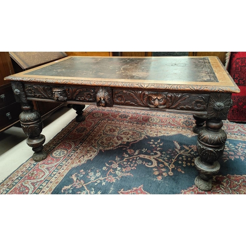 1001 - A large 19th century oak gothic style carved desk with two drawers with the green man carved decorat... 