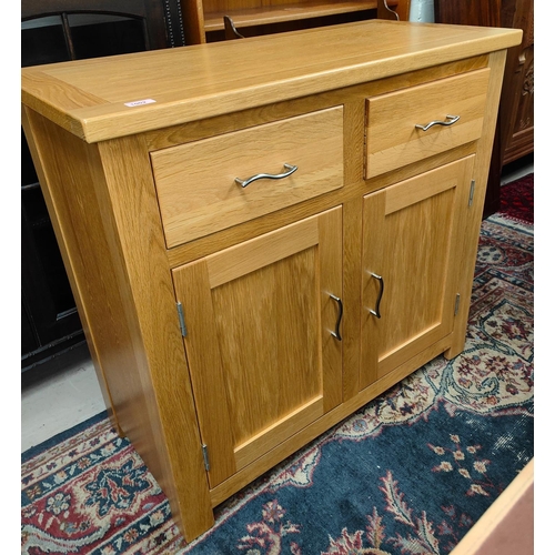 1002 - A modern light oak side cabinet of two doors and two drawers