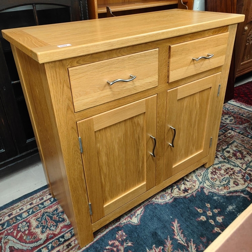 1002 - A modern light oak side cabinet of two doors and two drawers