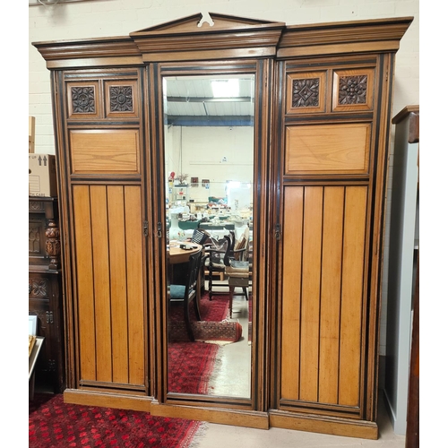 1015 - A 19th century ash triple wardrobe in the style of Lamb of Manchester with ebonised mouldings and in... 