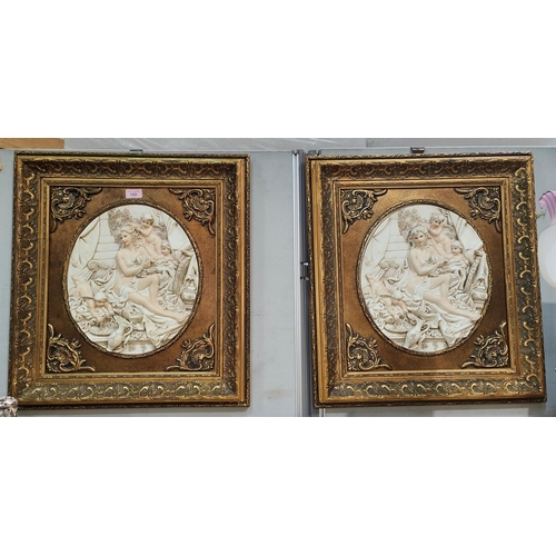 108 - A pair of wall plaques with relief panels of cherubs, in gilt frames