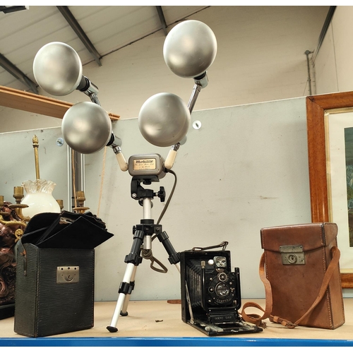32 - A GRAIL travelling lamp, a Mobilite photo spotlight, a Goerz folding camera with plates
