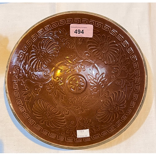 494 - A Chinese Ox-blood coloured bowl with embossed decoration of flowers, dia. 22cm