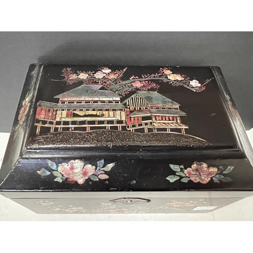 516 - A Japanese Meiji period lacquer tea caddy inlaid with mother of pearl, building to top and flowers a... 