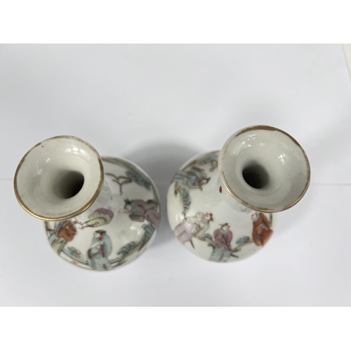 551 - A pair of 18th/19th century Chinese famille rose vases decorated with people in robes, gilt rim, ht.... 