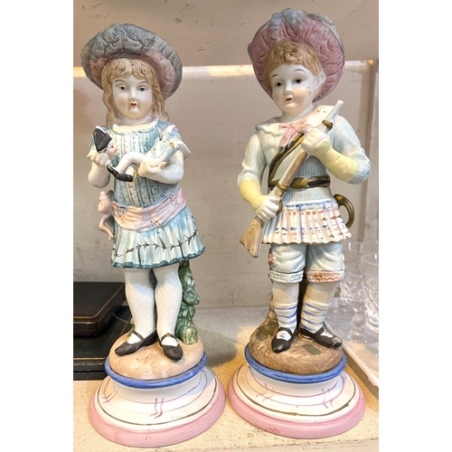 568 - A 19th century French style pair of coloured bisque figures of a boy a girl