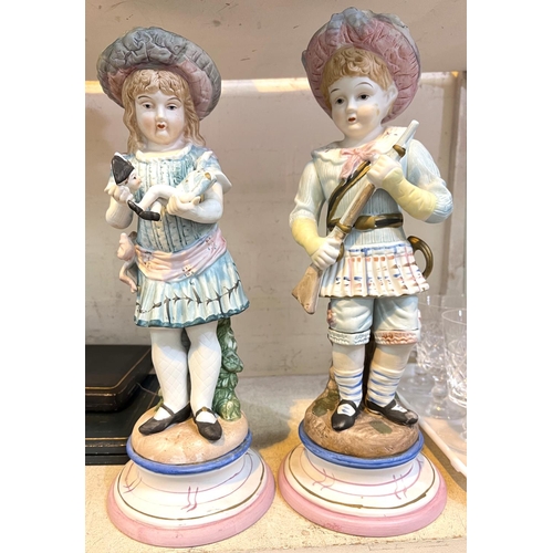 568 - A 19th century French style pair of coloured bisque figures of a boy a girl