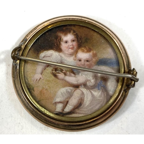 701 - A gold plated brooch, double sided with prints depicting Nelson and 2 children