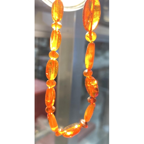 702 - An amber bead necklace and earrings