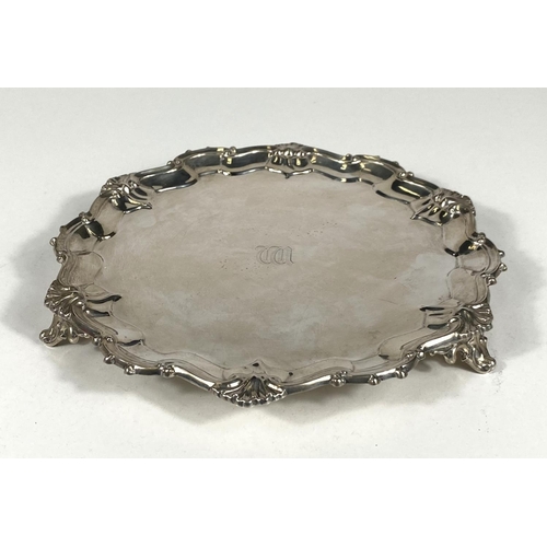 713 - A hallmarked silver circular salver in the Georgian style with scroll and shell border, London 1926,... 