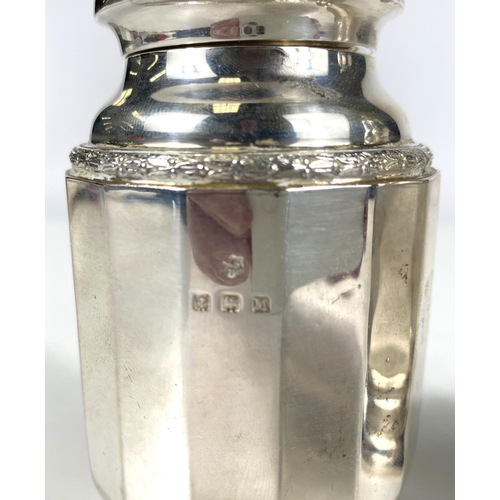 714 - A hallmarked silver pair of sugar dredgers in the Georgian style with pierced domed tops and ribbed ... 