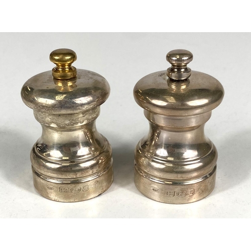 719 - A hallmarked silver pair of pepper grinders, London, date marks worn