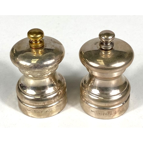 719 - A hallmarked silver pair of pepper grinders, London, date marks worn