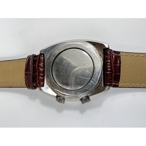 747 - A mid 20th century gents Bucherer Alarm gents wristwatch with silvered dial, steel case alarm compli... 