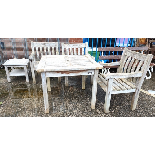 852 - A teak garden set table and three chairs plus covers