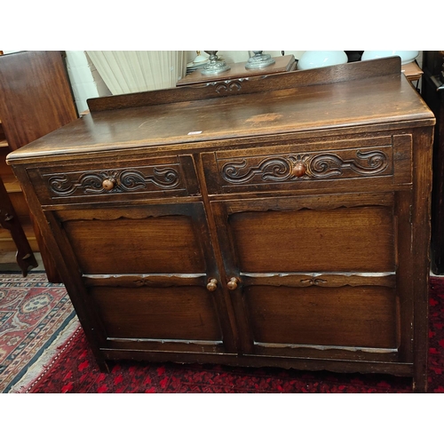 911 - A 1930's oak Jacobean style sideboard of 2 cupboards and 2 drawers