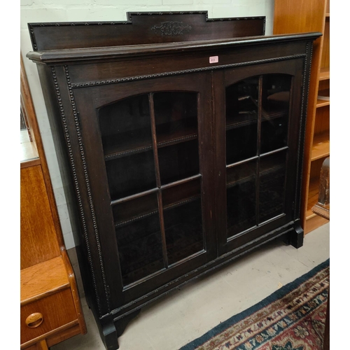 913 - A 1930's oak bookcase enclosed by 2 glazed doors