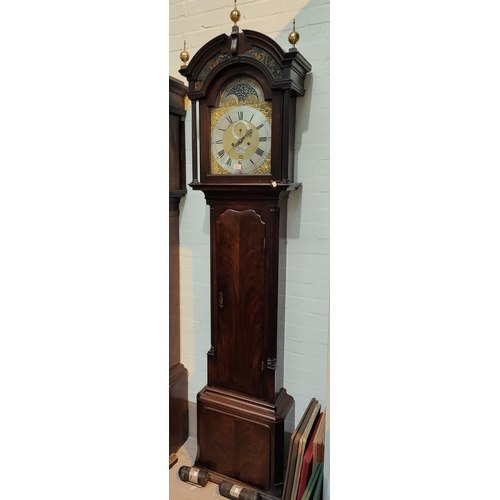 1012 - An 18th century figured mahogany longcase clock, the hood with arched pediment, brass finials, glass... 