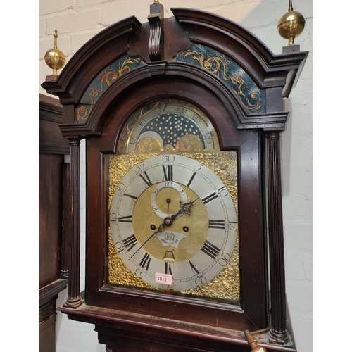 1012 - An 18th century figured mahogany longcase clock, the hood with arched pediment, brass finials, glass... 