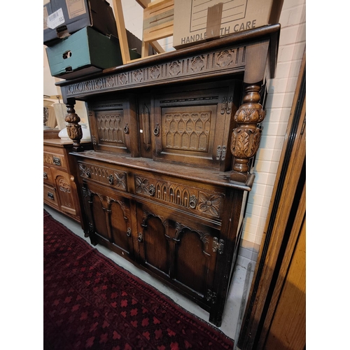 840 - An oak draw leaf dining table with bulbous legs and an oak carved wooden buffet sideboard with cupbo... 