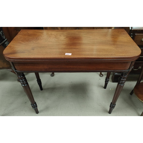 869 - A mahogany tea table with turned legs, rounded rectangular folding top. 