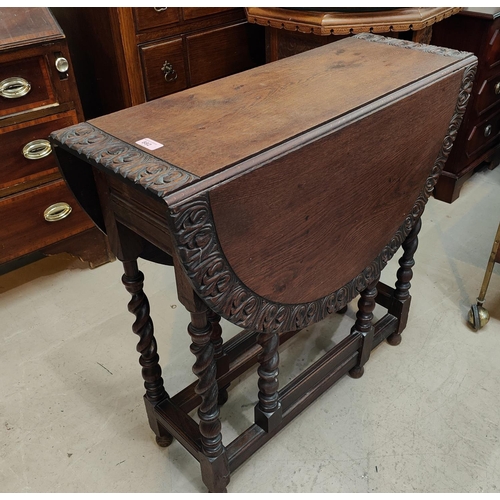 882 - A carved oak dining table with drop leaf top